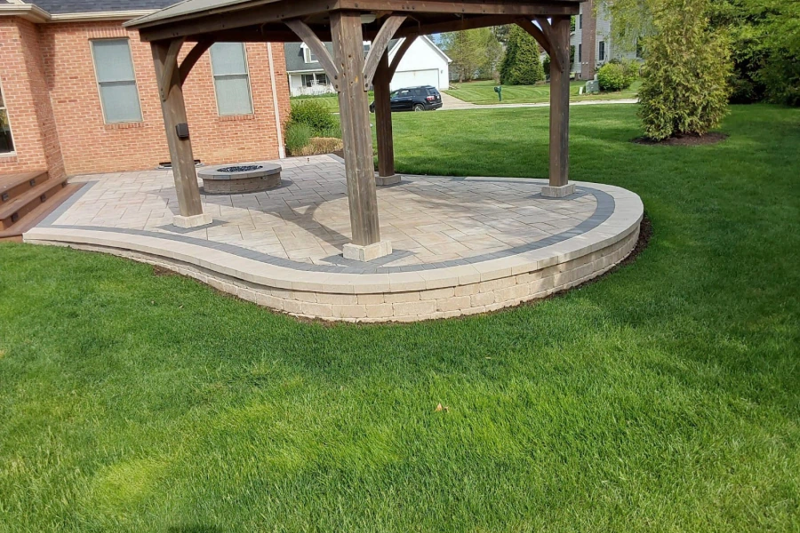 house with a firepit in the patio with grass around