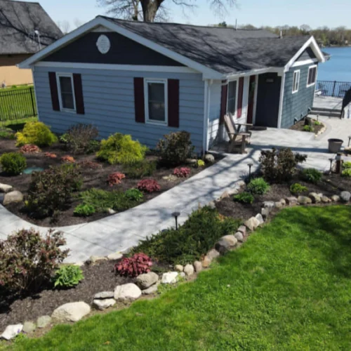 light blue house with a dark grey roofing a patio outside