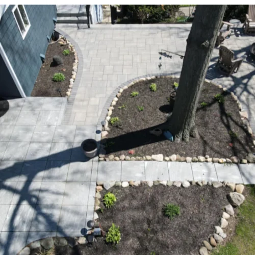 patio with a paved floor and trees with stones around